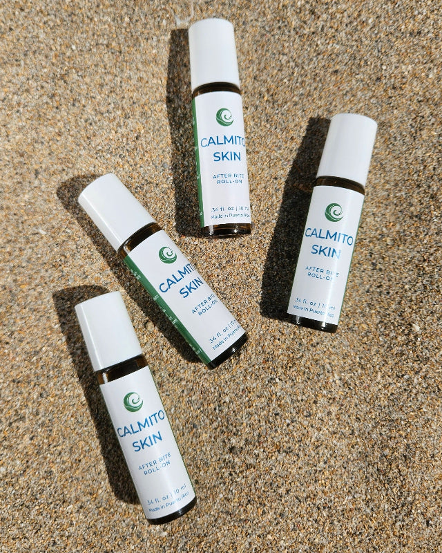 Four bottles of Calmito Skin Rollon in the sand